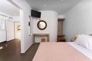 um quarto com uma cama e um espelho na parede em Zaitun Luxury Suites em Karterados