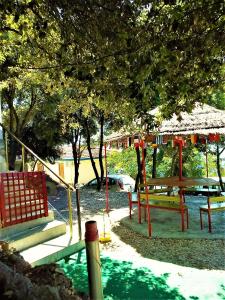 a playground with a bench and a table under a tree at Ramo's Green Beachside Retreat - Cozy 2 Bedroom Home in Vlorë