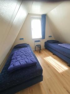 - une chambre mansardée avec 2 lits et une fenêtre dans l'établissement Vakantiehuisje in Gramsbergen, à Gramsbergen 27 autres photos
