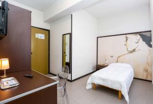 een slaapkamer met een bed, een bureau en een televisie bij Hotel Solarium in Civitanova Marche