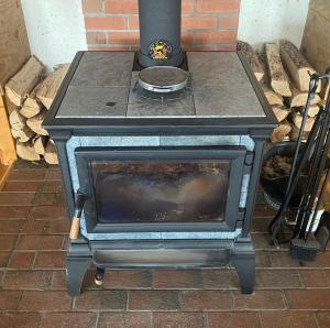 an old wood stove sitting in front of a brick oven at Renovated Barn 100 Acres For Retreats & Weddings in Hardwick
