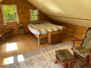 ein Schlafzimmer mit einem Bett und einem Stuhl in einer Hütte in der Unterkunft Renovated Barn 100 Acres For Retreats & Weddings in Hardwick