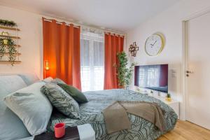 a bedroom with a bed and a clock on the wall at Easy Paris Visit Metro & Parking in Saint-Ouen