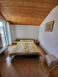 a bedroom with a large bed with a wooden ceiling at Apartmani Mira in Rab