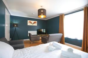 una camera con un letto e due sedie e una scrivania di Spacious 4BR City Centre Apartment w/ Free Parking a Edimburgo