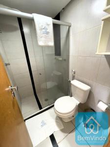 a bathroom with a toilet and a glass shower at Apartamento com linda vista mar no Bahia Suites in Salvador