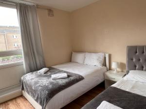 a small bedroom with two beds and a window at 2-bedroom Flat in Regents Park-Euston-Camden in London
