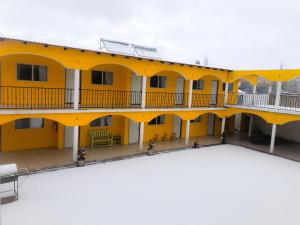 a yellow building with a large courtyard at Hotel Posada del Cobre in Creel