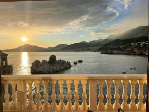 un balcón con vistas al agua y a la puesta de sol en Pržno Luxury Apartments en Sveti Stefan