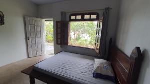 a bedroom with a bed and a window and a door at VARANDA DO RIO NEGRO in Manaus