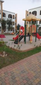 a playground with a slide in a park at SALICORNE 1 marina saidia appt in Saïdia