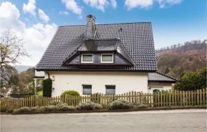 a white house with a black roof and a fence at Gorgeous Apartment In Detmold With House A Panoramic View in Detmold