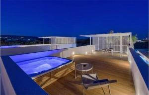 Plaia GrandeGorgeous Home In Marina Di Ragusa的一座房子,在晚上在甲板上设有游泳池