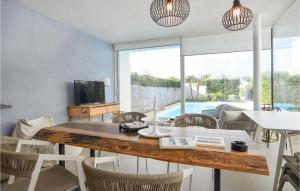 Plaia GrandeGorgeous Home In Marina Di Ragusa的配有木桌椅的餐厅 更多7张照片