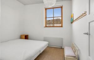 een witte slaapkamer met een bed en een raam bij Cozy Home In Vejby With Kitchen in Vejby