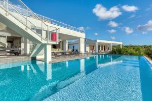 uma grande piscina em frente a uma casa em Villa Grand Palms em Les Terres Basses