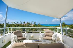 uma varanda com duas cadeiras e uma mesa num barco em Villa Grand Palms em Les Terres Basses