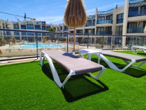 a bench sitting on the grass in front of a building at LOLA'S HOME in Cotillo
