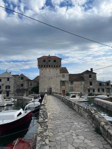 a large stone building with boats in a harbor at Apartment Frane in Kaštela