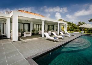 a villa with a swimming pool and chairs and a house at Villa Monte Verde in Orient Bay