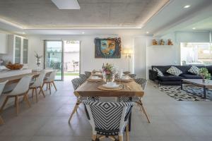eine Küche und ein Wohnzimmer mit einem Tisch und Stühlen in der Unterkunft Elegante y moderna Villa Miami in Adeje
