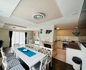 eine Küche und ein Esszimmer mit einem weißen Tisch und Stühlen in der Unterkunft Villa Holiday in Baltschik