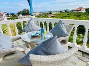 a glass table on a balcony with pillows at The Citrus House in Kalavárda