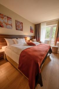 a bedroom with a large bed and a window at Hotel Schwarzbachtal Hideaway in Erlbach