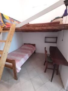 a small room with a bunk bed and a desk at La Casa Amarilla CENTRO in San Rafael