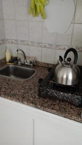 a tea pot sitting on a counter next to a sink at La Casa Amarilla CENTRO in San Rafael