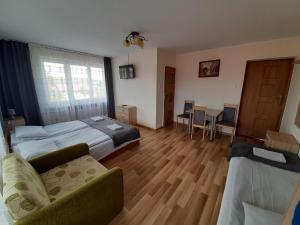 1 dormitorio con cama, sofá y mesa en Noclegi Michaś, en Krasnobród