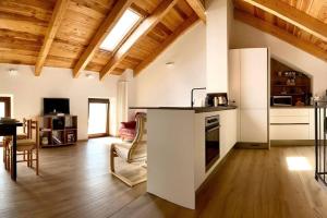 een woonkamer met een keuken met een aanrecht en een tafel bij La mansarda di Crevari in Genua