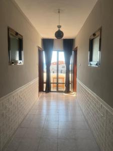 a hallway with a view of a room with windows at Deniz Kızı Otel Çeşme in Çeşme