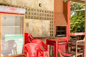 - un ensemble de chaises et de tables rouges sur une terrasse dans l'établissement Chacara c piscina e lazer Sao Lourenco da Mata PE, à São Lourenço da Mata