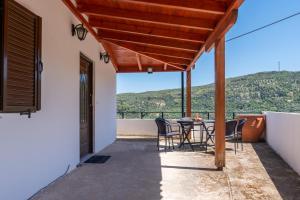 a view from the balcony of a house with a table and chairs at AGGELIKI'S traditional country cottage in Topólia