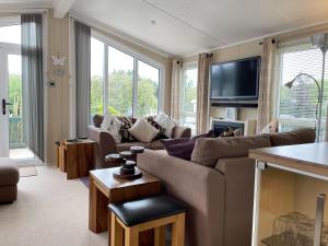 een woonkamer met een bank en een tv bij Beautiful 6 Berth Lodge At Cherry Tree Holiday Park Ref 70002tg in Great Yarmouth