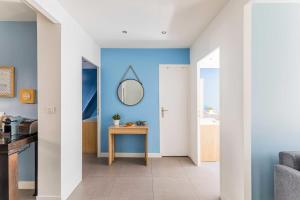 um corredor com paredes azuis e uma mesa com um espelho em Bright apartment - 2BR - Place de la BastilleSt Antoine em Paris