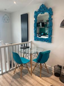 a dining room with a glass table and chairs and a mirror at Studio Tavros in Bristol