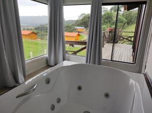 a white bath tub in a room with a window at Hospedaria Kayser Haus in Urubici +268 photos