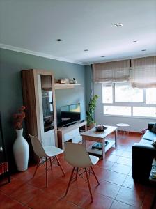 a living room with chairs and a table and a tv at Marvera in Caldas de Reis