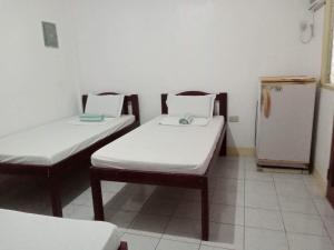 a room with two beds and a refrigerator at Pescador View Extension near the Ocean in Moalboal
