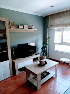 a living room with a tv and a coffee table at Marvera in Caldas de Reis