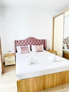 una camera con un grande letto con testiera viola di Miluna Luxury Studios & Apartments a Eforie Nord