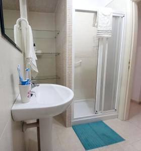 ein Badezimmer mit einem weißen Waschbecken und einer Dusche in der Unterkunft Disfruta en 1ª línea de playa in Puertito de Güímar