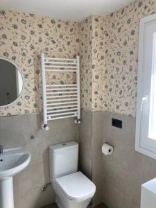 a bathroom with a white toilet and a sink at Piso acogedor entre mar y montaña in Posada de Llanes +5 photos