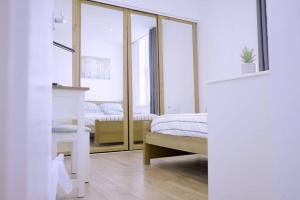 a bedroom with two beds and a mirror at Apartment in West Yorkshire 3 in Keighley