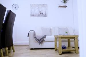 a living room with a white couch and a table at Apartment in West Yorkshire 3 in Keighley