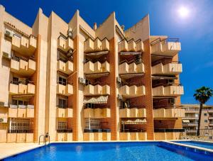 un edificio con piscina frente a él en Holiday Royal Suite Concordia, en Torrevieja