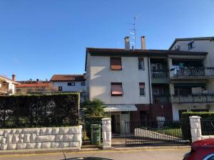 a white building with a fence in front of it at Apartment Chie in Izola