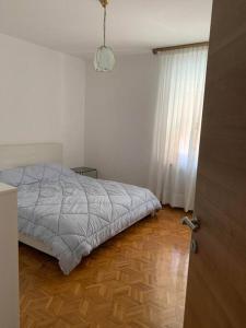 a bedroom with a bed and a wooden floor at Apartment Chie in Izola